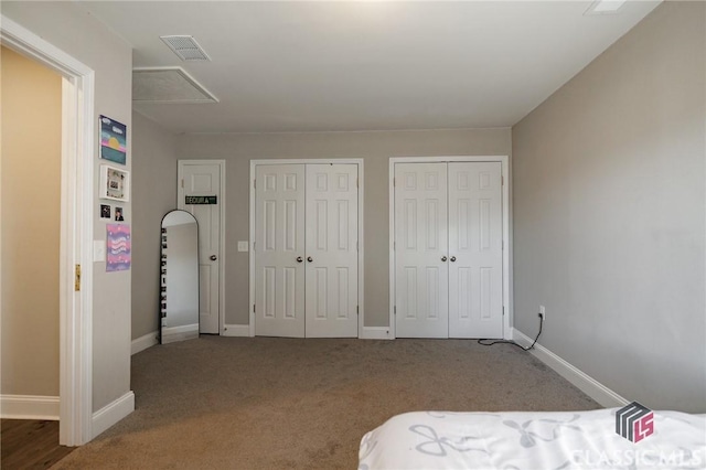 bedroom with carpet flooring and two closets