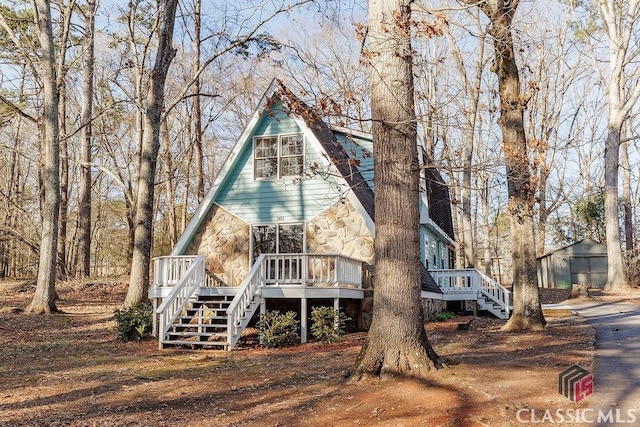 view of front of home featuring a wooden deck and a storage unit