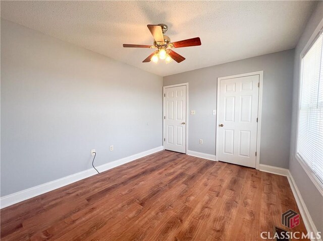 unfurnished bedroom featuring ceiling fan, a closet, light hardwood / wood-style floors, and a textured ceiling