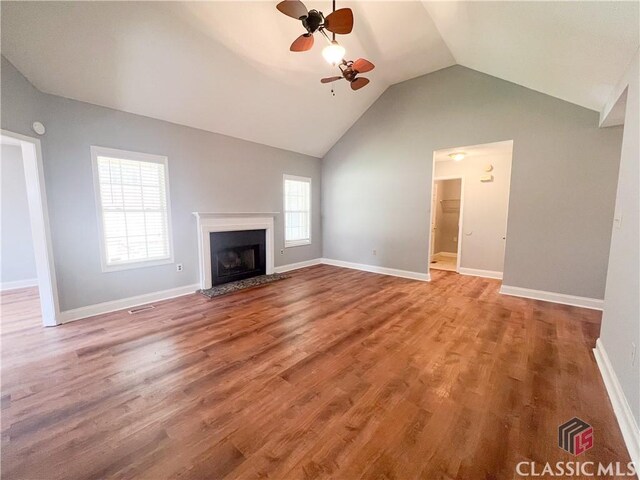 spare room featuring a tray ceiling, ceiling fan, and light wood-type flooring