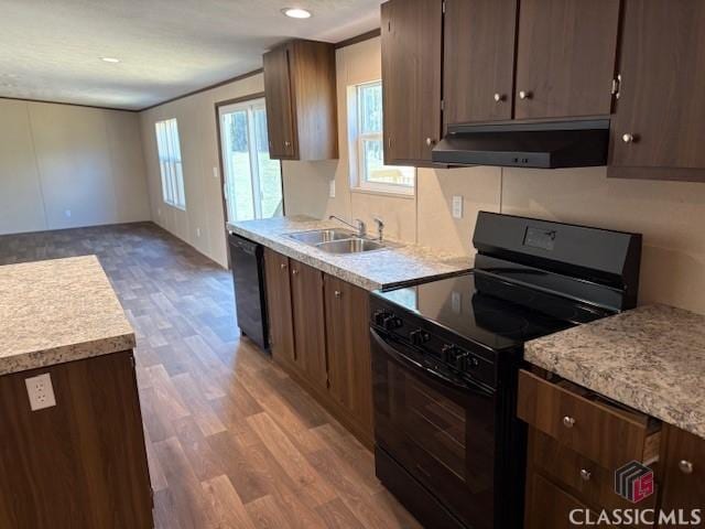 kitchen with sink, dark brown cabinets, light hardwood / wood-style flooring, and black appliances