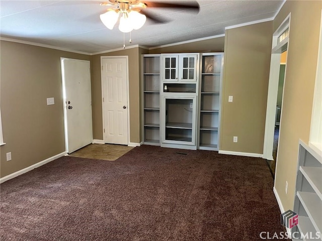 unfurnished living room with crown molding, ceiling fan, and dark colored carpet