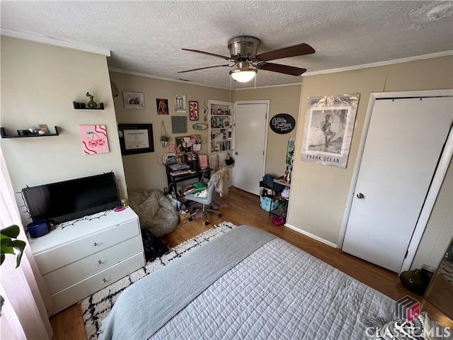 bedroom with hardwood / wood-style flooring, crown molding, and a textured ceiling