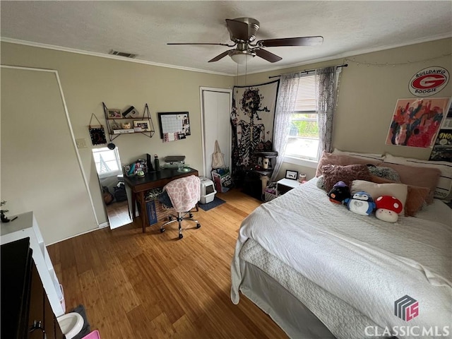 bedroom featuring crown molding, hardwood / wood-style floors, and ceiling fan