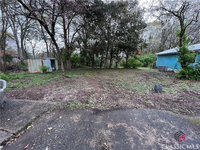 view of yard featuring a shed and central air condition unit