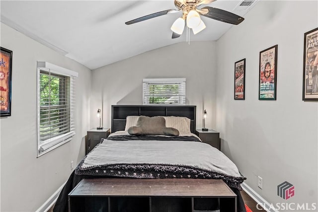 bedroom with multiple windows, lofted ceiling, hardwood / wood-style flooring, and ceiling fan