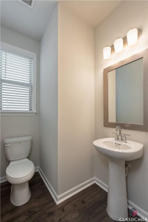 bathroom with lofted ceiling, toilet, and hardwood / wood-style floors