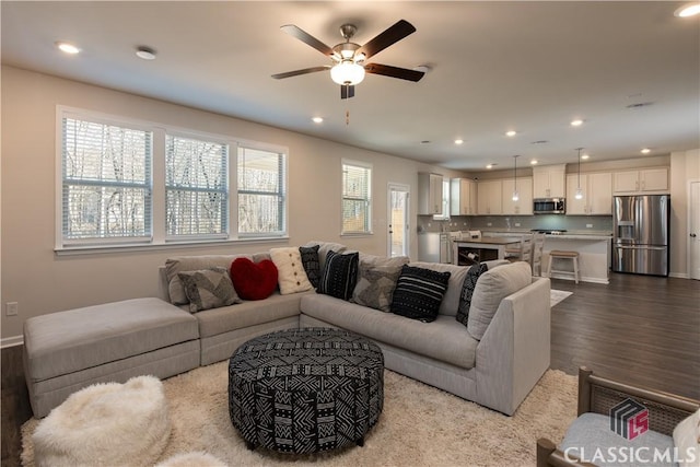 living room with ceiling fan and light hardwood / wood-style flooring