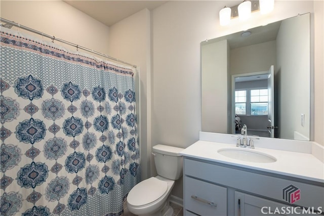 bathroom with vanity, a shower with shower curtain, and toilet