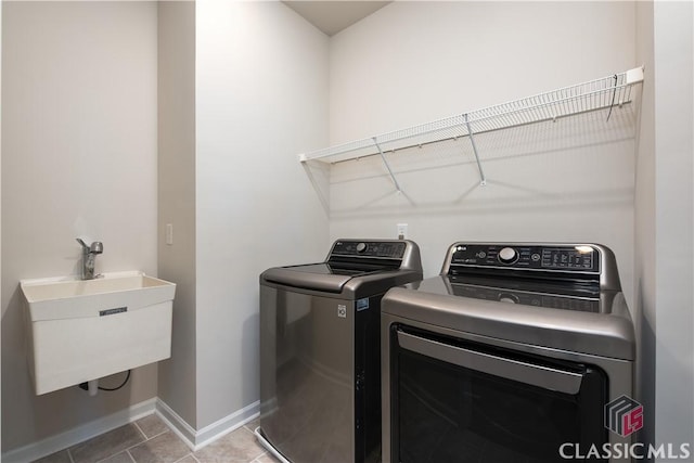 laundry room featuring washer and dryer, sink, and tile patterned floors