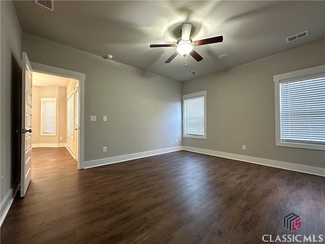 spare room featuring dark wood-type flooring and ceiling fan