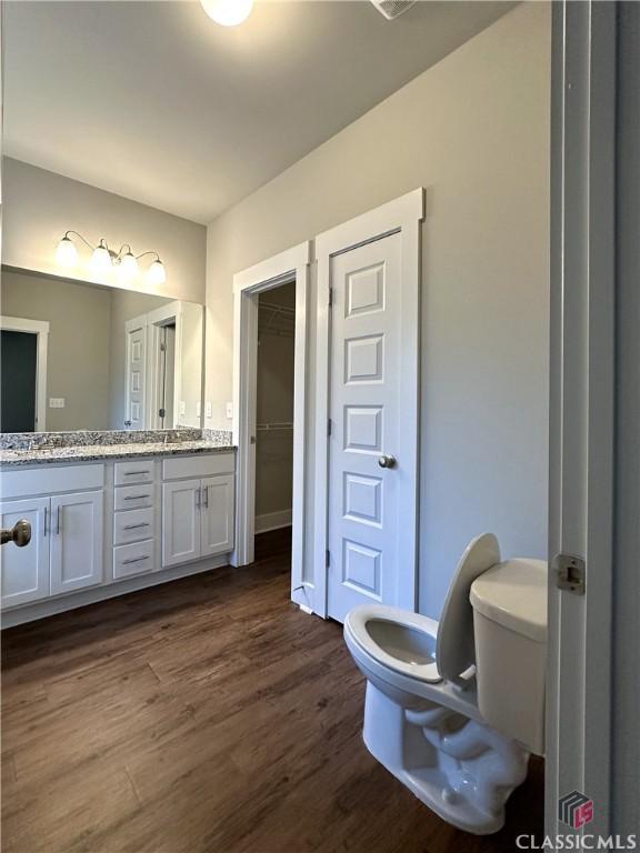 bathroom featuring vanity, hardwood / wood-style floors, and toilet