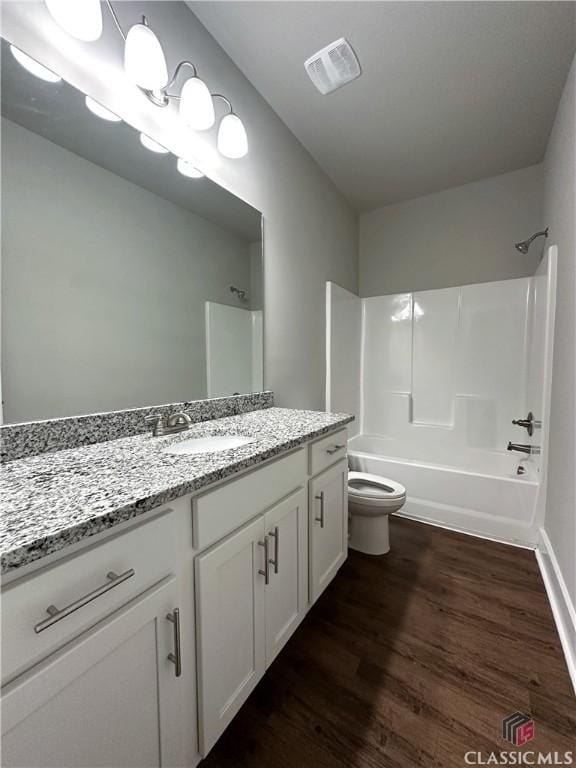 full bathroom with vanity, wood-type flooring,  shower combination, and toilet