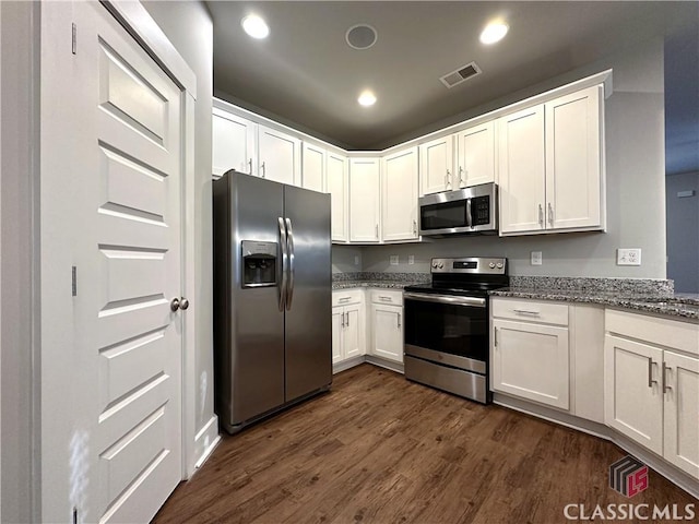 kitchen featuring white cabinetry, appliances with stainless steel finishes, dark hardwood / wood-style floors, and light stone countertops