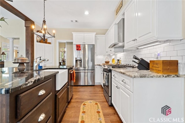 kitchen featuring stone counters, pendant lighting, stainless steel appliances, and white cabinets