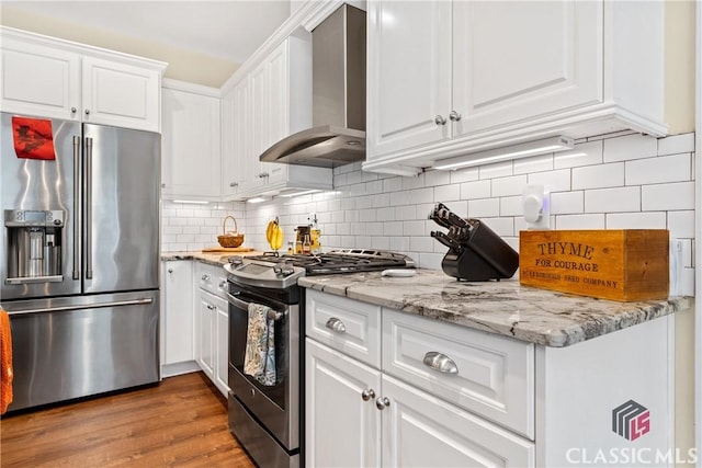 kitchen with white cabinetry, wall chimney exhaust hood, and appliances with stainless steel finishes