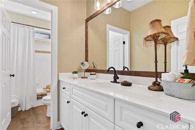 full bathroom with hardwood / wood-style flooring, vanity, shower / bath combination with curtain, and toilet