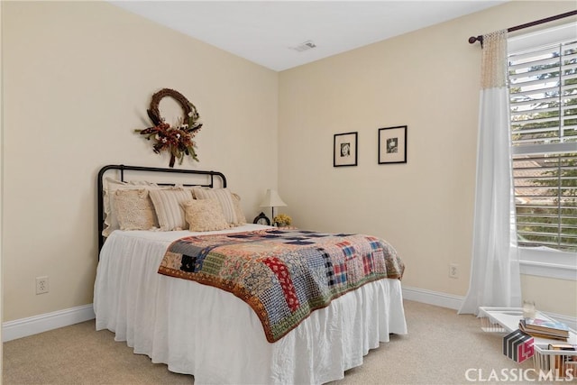 bedroom featuring light carpet and multiple windows