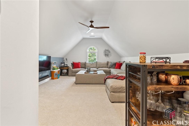 living room with lofted ceiling, ceiling fan, and carpet