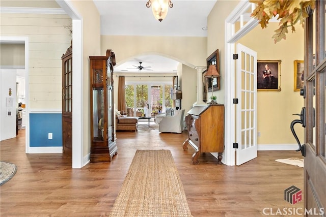 foyer with french doors, ceiling fan, wood-type flooring, and decorative columns