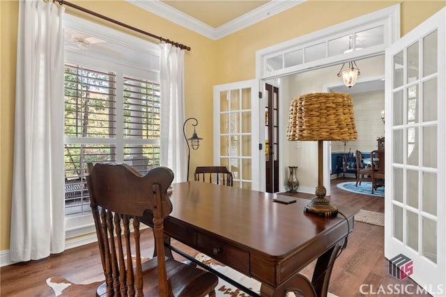 dining space with hardwood / wood-style flooring, ornamental molding, and french doors