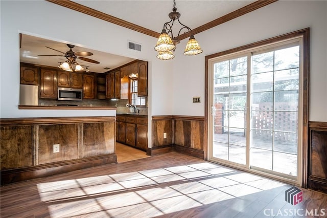 kitchen with pendant lighting, fridge, kitchen peninsula, and light wood-type flooring