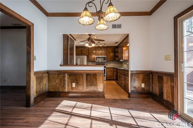 kitchen featuring ornamental molding, appliances with stainless steel finishes, sink, and light hardwood / wood-style flooring