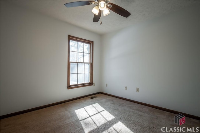 carpeted spare room with ceiling fan and a textured ceiling