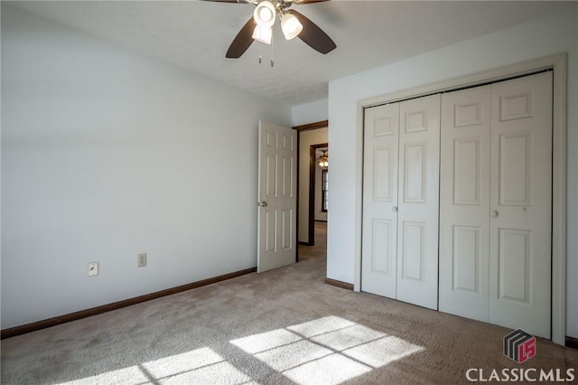 unfurnished bedroom featuring ceiling fan, light colored carpet, and a closet