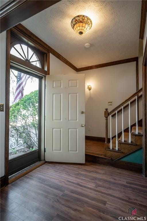 foyer entrance featuring crown molding, dark hardwood / wood-style flooring, and a textured ceiling