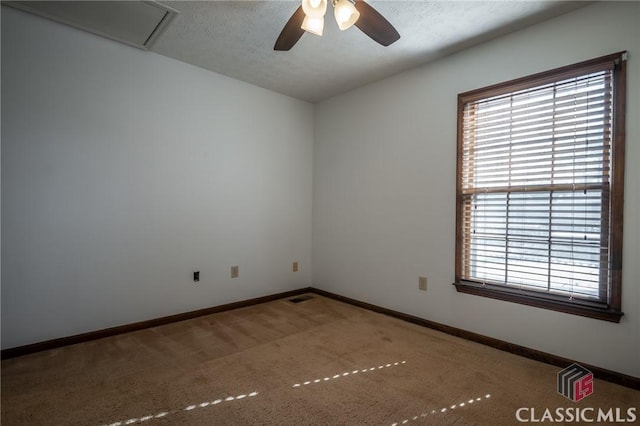 carpeted empty room with ceiling fan and a textured ceiling