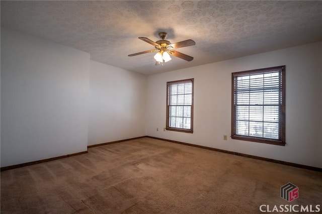 empty room featuring ceiling fan, carpet floors, and a textured ceiling