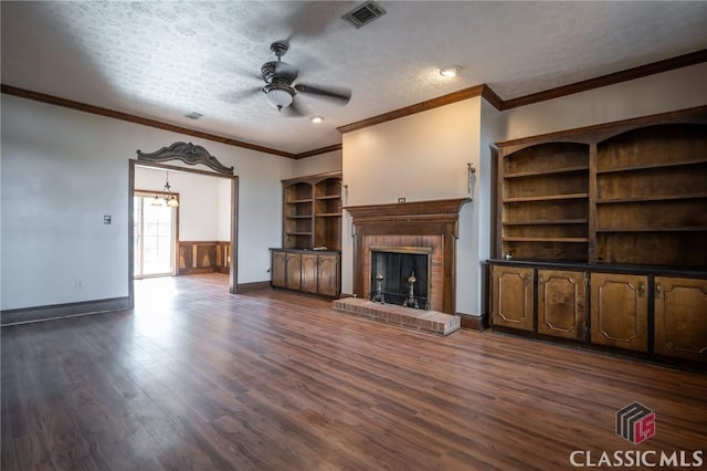 unfurnished living room featuring ceiling fan, a fireplace, dark hardwood / wood-style floors, and a textured ceiling