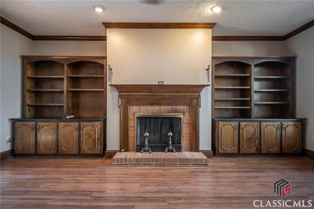 unfurnished living room with ornamental molding, a brick fireplace, and dark wood-type flooring