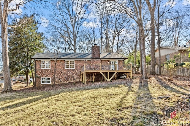 back of house featuring a deck and a lawn