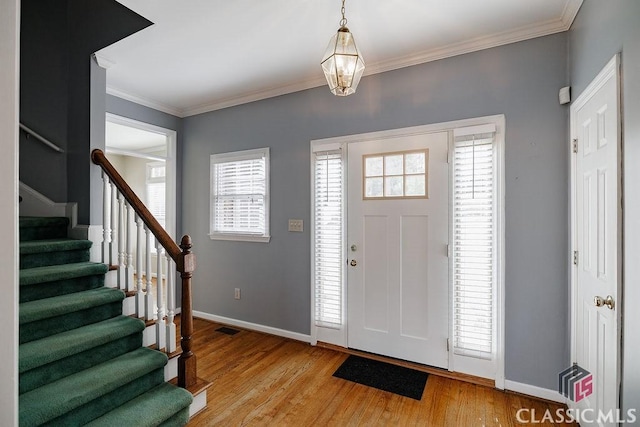 foyer with ornamental molding and light wood-type flooring