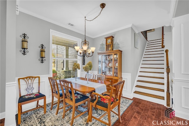 dining space with ornamental molding, dark hardwood / wood-style floors, and a chandelier