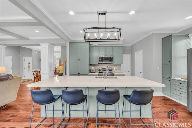 kitchen with a spacious island, appliances with stainless steel finishes, a breakfast bar, and pendant lighting