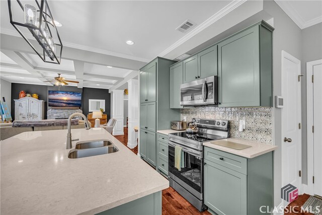 kitchen with sink, stainless steel appliances, green cabinetry, and ornate columns