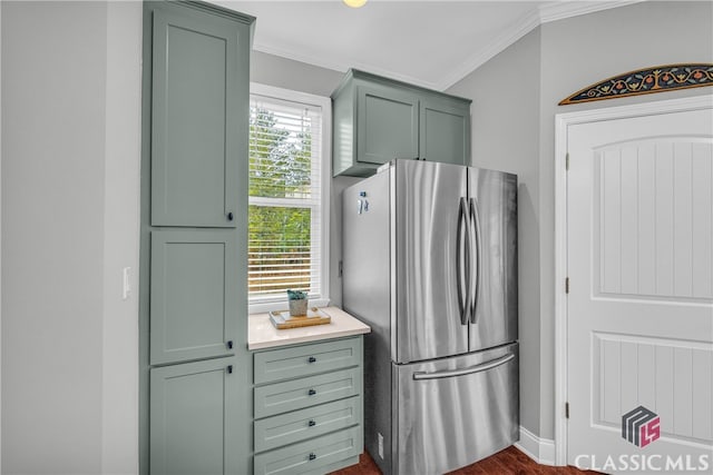 kitchen with stainless steel refrigerator, crown molding, and green cabinets