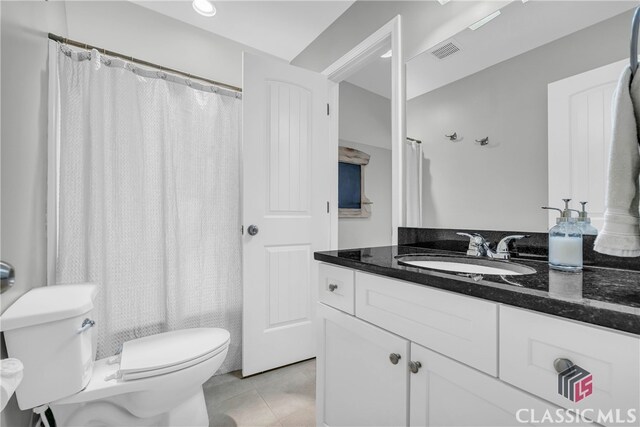 bathroom featuring vanity, toilet, and tile patterned flooring