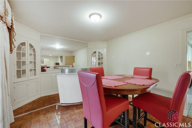 dining space with light parquet floors and ornamental molding