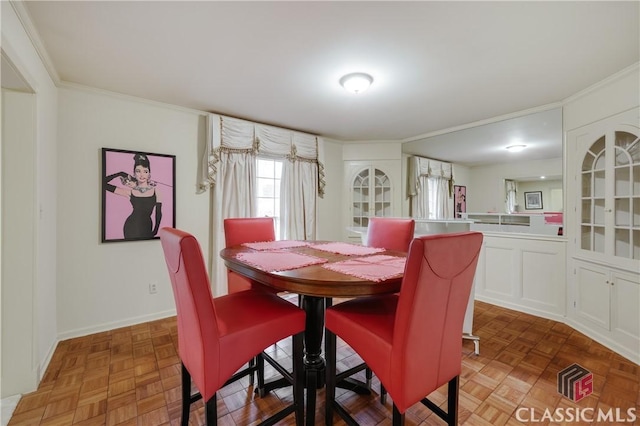 dining room featuring ornamental molding and parquet flooring