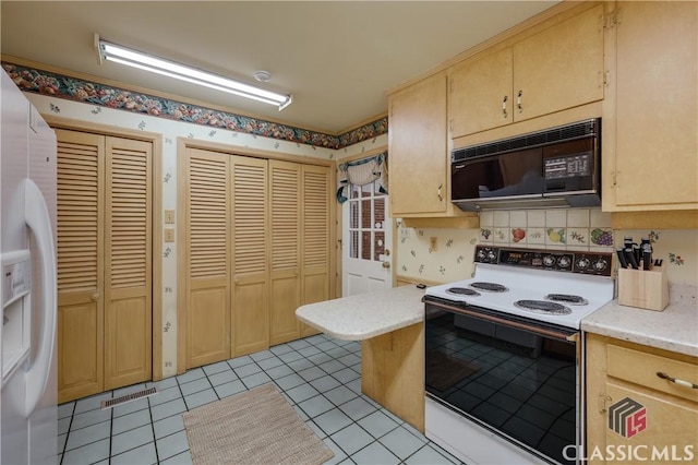 kitchen with light tile patterned floors, light brown cabinetry, and white appliances