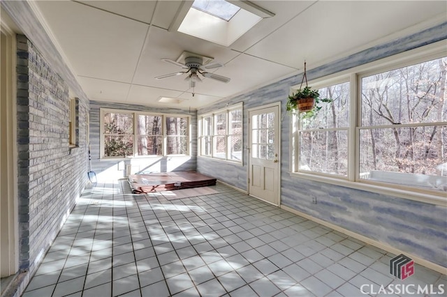 unfurnished sunroom featuring ceiling fan and a skylight