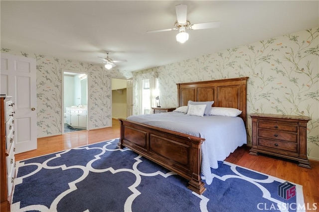 bedroom with hardwood / wood-style flooring, ceiling fan, and ensuite bath