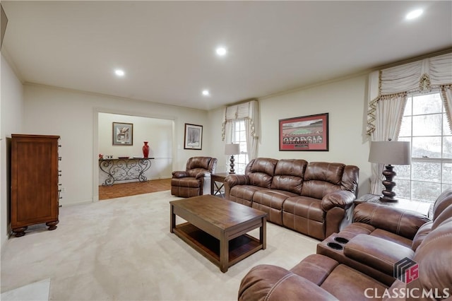 carpeted living room featuring crown molding and a wealth of natural light