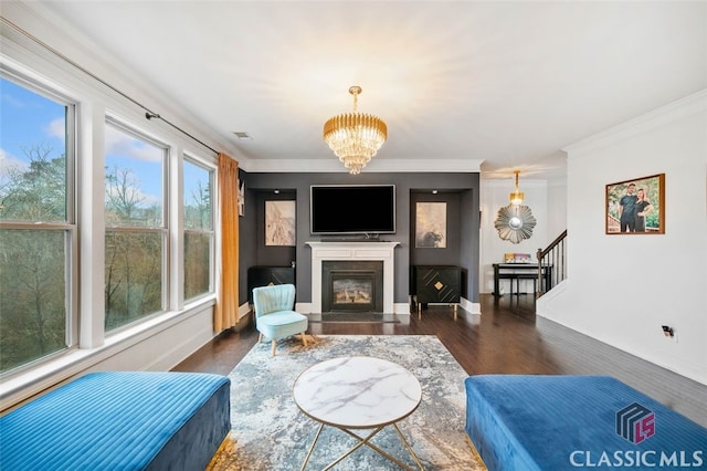 living room with dark hardwood / wood-style flooring, a chandelier, and crown molding