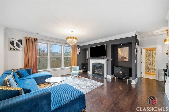 living room featuring ornamental molding, dark hardwood / wood-style floors, and a chandelier