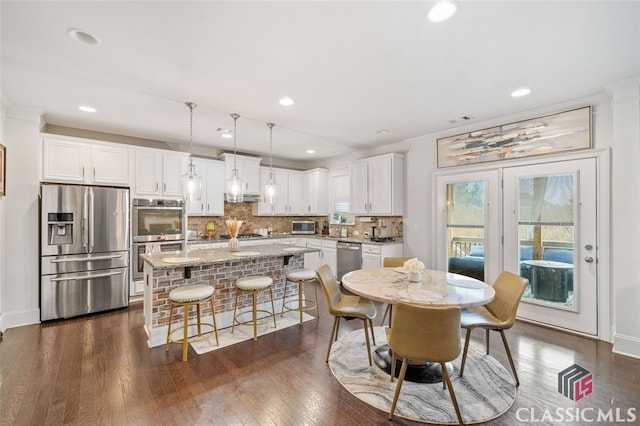 dining space featuring dark wood-type flooring and crown molding